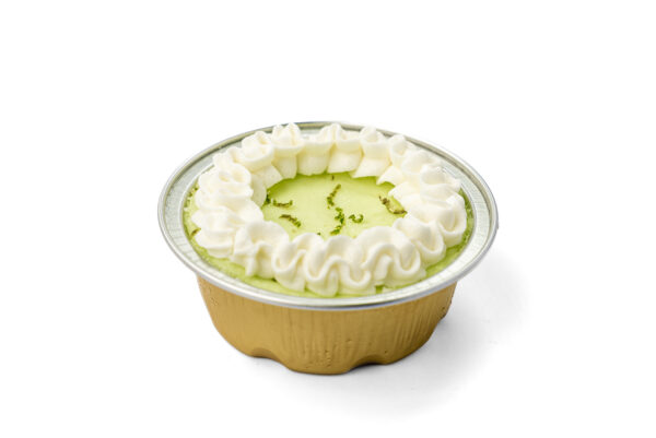 close up view key lime pie mini cheesecake with whip cream on top in a mini cup